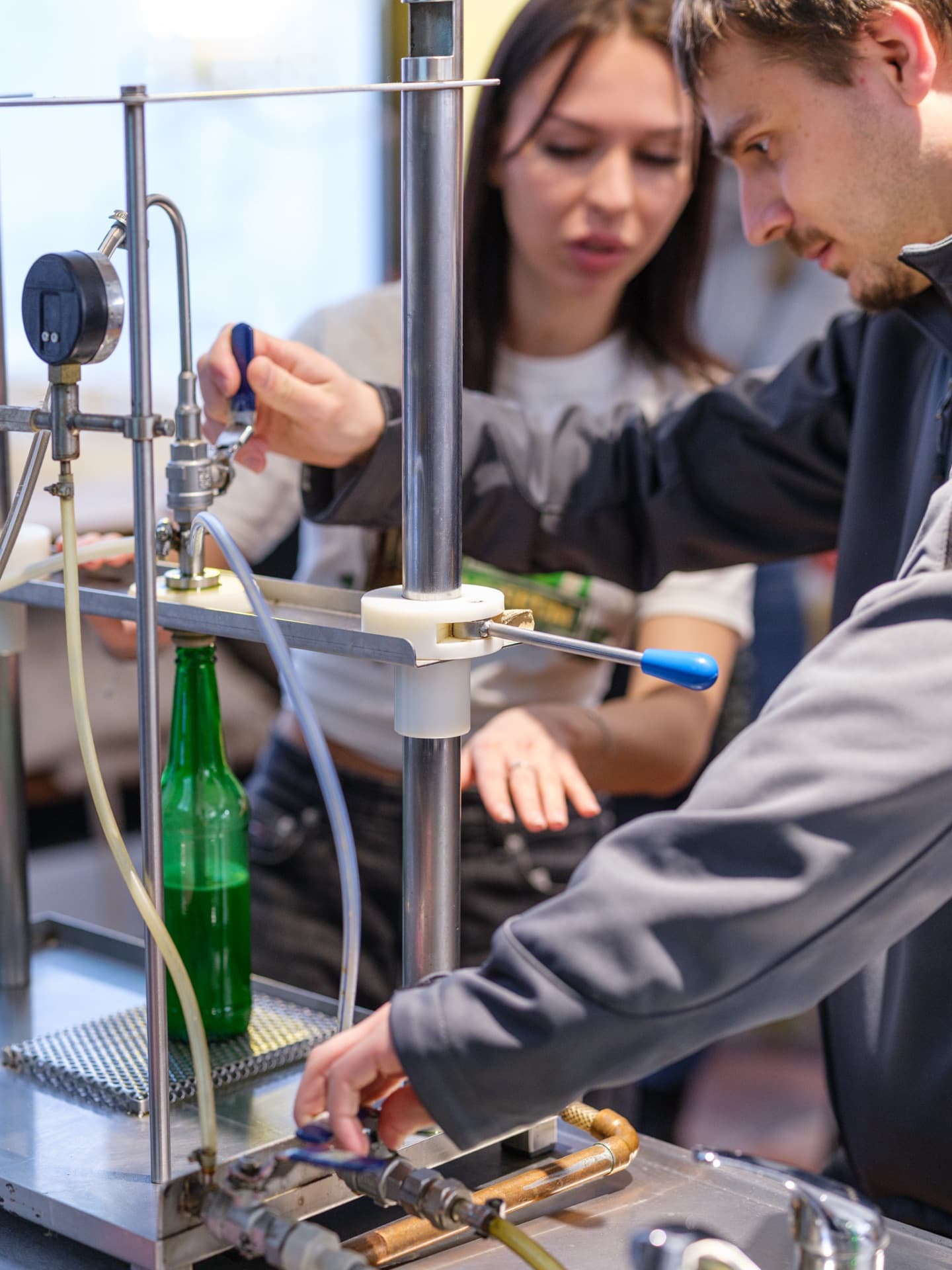 Visitors filling their own bottle of beer on the manual filling line during the Beer Experience
